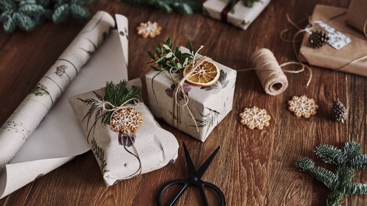 Die Weihnachtsgeschenke warten auf dem Tisch, eingewickelt in Blumentapeten- eine nachhaltigere Weihnachtsgeschenkverpackung.