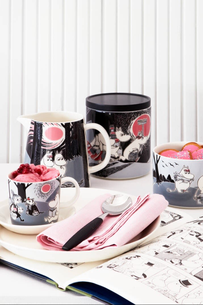 Die Mumin-Adventure-Kollektion, bestehend aus Tasse, Teller, Kanne, Dose und Schale steht auf einem Tisch.