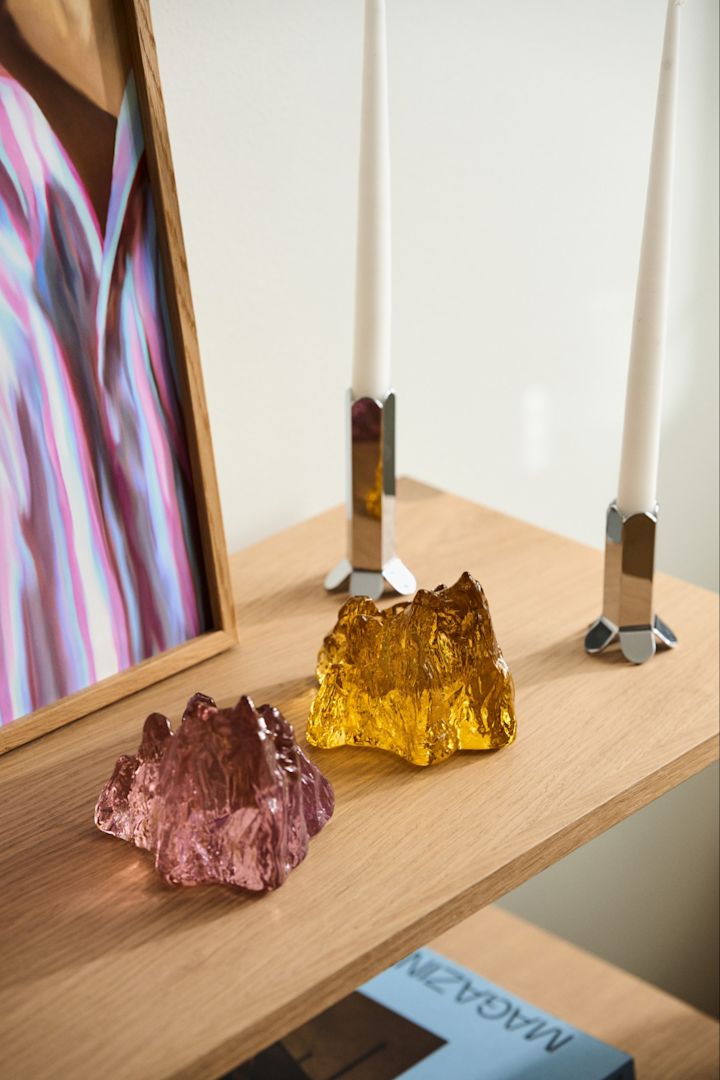 Geschenkideen zu Weihnachten: Hier sehen Sie zwei Windlichter aus der Calore-Kollektion von Byon auf einem Beistelltisch stehen, dahinter eine Vase.