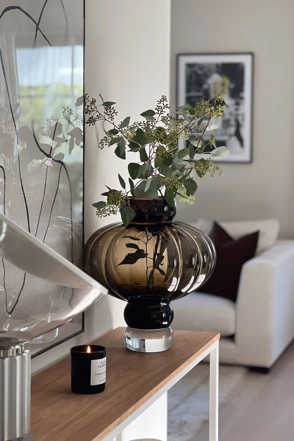 Auf einem Regal steht eine braune Balloon Vase von Louise Roe mit frischen Schnittblumen darin.