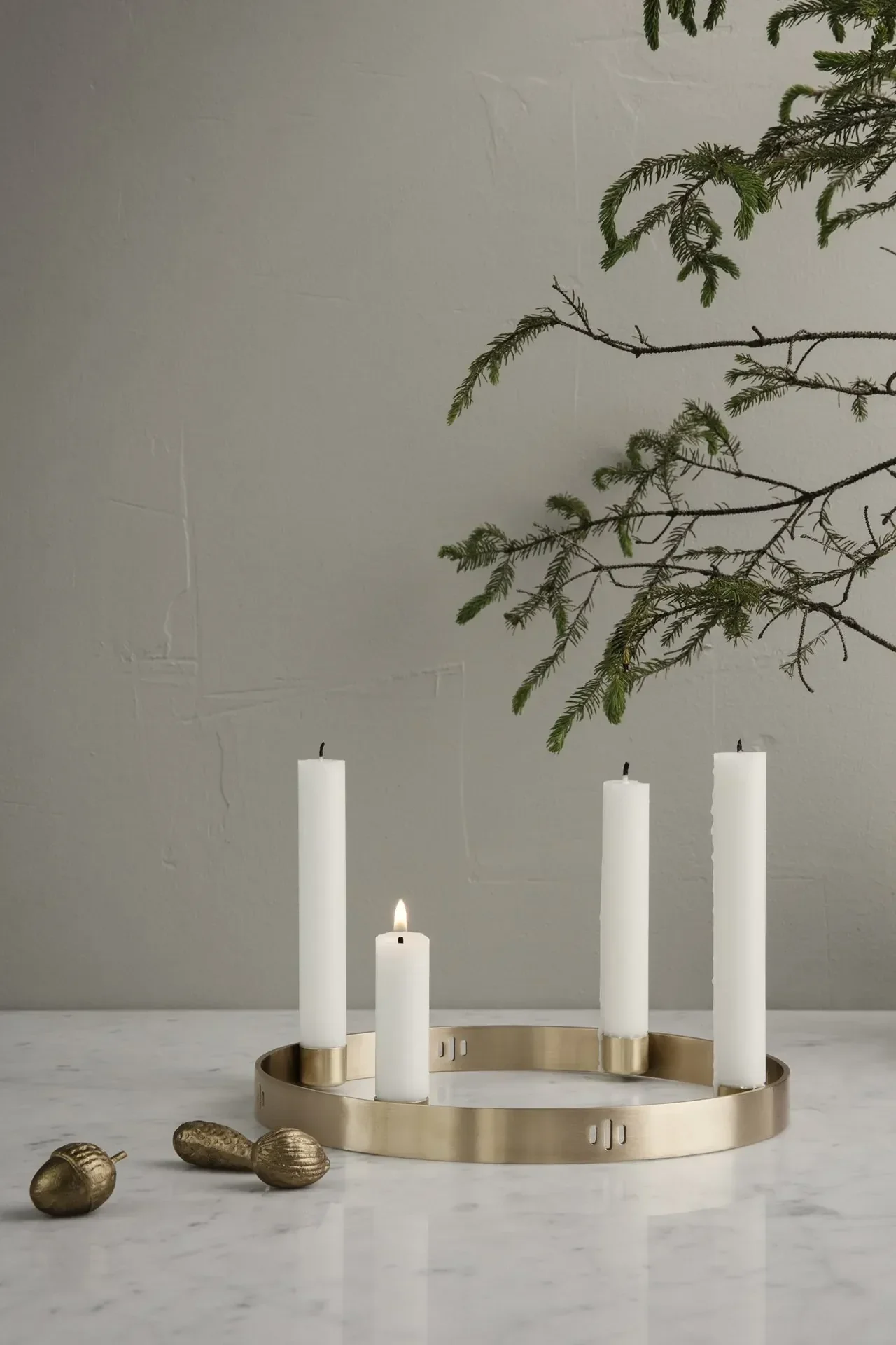 In einem schlichten Ambiente steht der Circle Messing Kerzenhalter von Ferm Living auf einem Tisch.