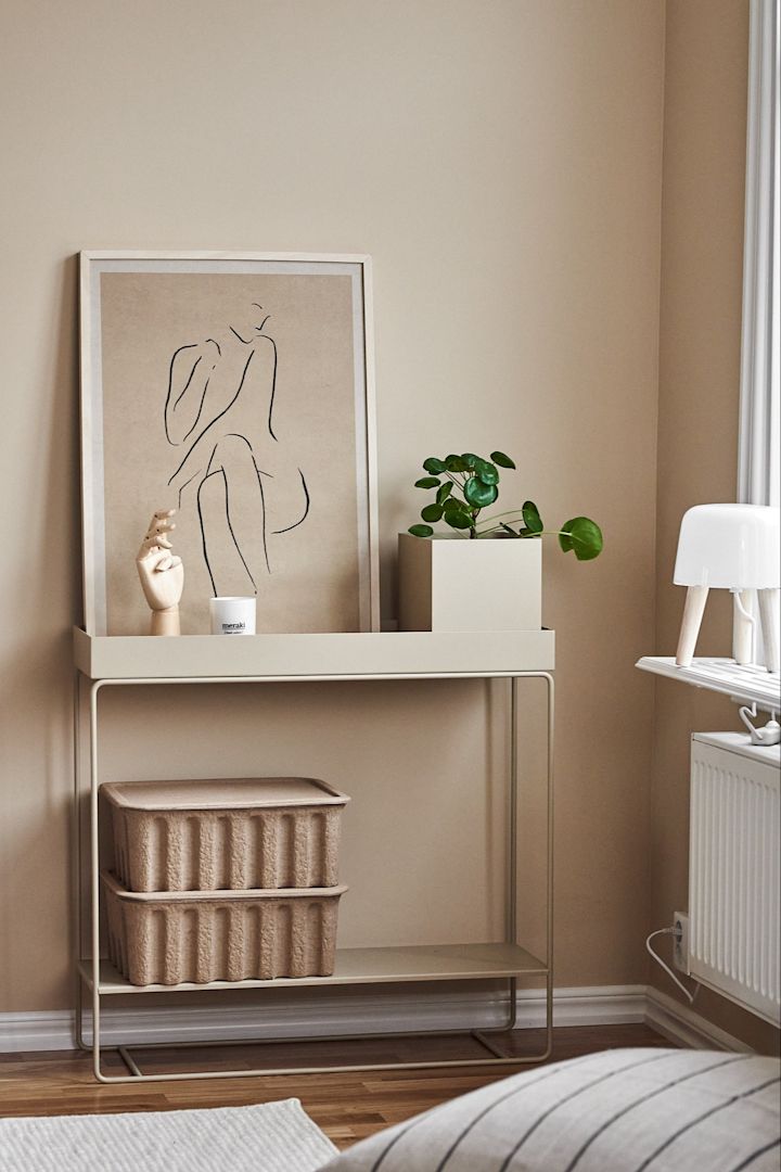 Dekorieren Sie Ihr Wohnzimmer mit beigen Ton-in-Ton-Möbeln, um einen stilvollen Look in Ihrem Zuhause zu schaffen. Hier sehen Sie die vielseitigen Plant Box-Konsolentische von Ferm Living zusammen mit Aufbewahrungsboxen und Grace-Postern von Paper Collective.