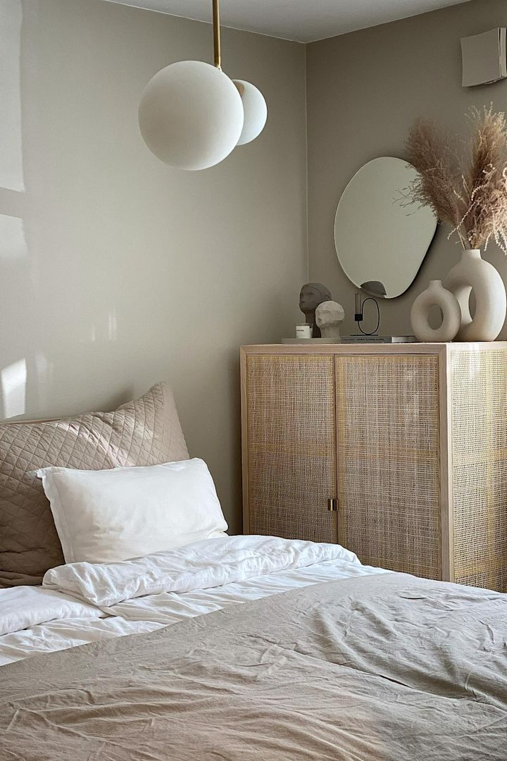11 stylische Pendelleuchten für Ihr Wohlfühlzuhause - hier sehen Sie die Pendelleuchte Twice von House Doctor, die über einem Bett in einem beigen Schlafzimmer hängt.