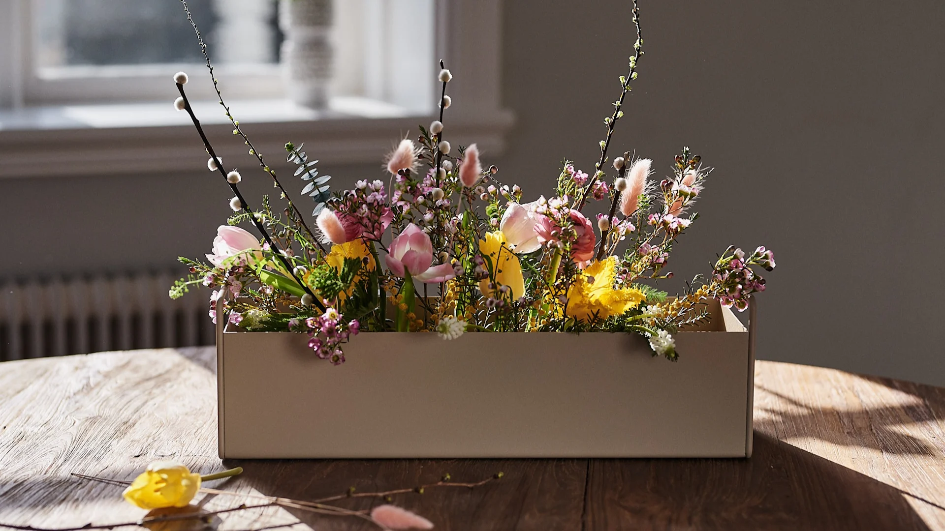 Frühlingserwachen: Die kleine beigefarbene Plant Box von Ferm Living steht mit Frühlingsblumen auf dem Tisch und inspiriert zur frühlingshaften Einrichtung.