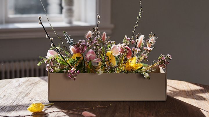 Frühlingserwachen: Die kleine beigefarbene Plant Box von Ferm Living steht mit Frühlingsblumen auf dem Tisch und inspiriert zur frühlingshaften Einrichtung.