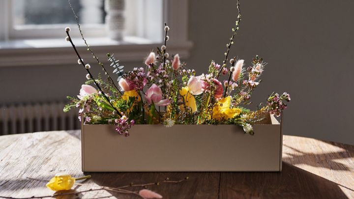 Frühlingserwachen: Die kleine beigefarbene Plant Box von Ferm Living steht mit Frühlingsblumen auf dem Tisch und inspiriert zur frühlingshaften Einrichtung.