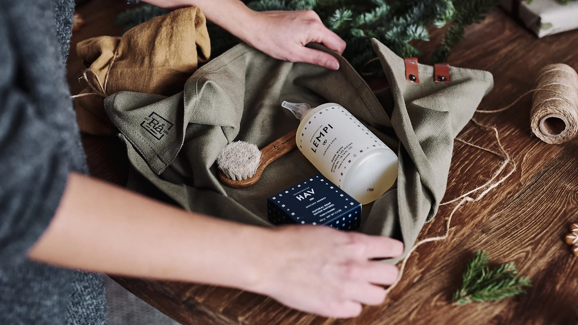 Ein Geschenkset aus Seifen und Bürste wird in ein Geschirrtuch gewickelt, um als Zero-Waste Geschenk verpackt zu werden.