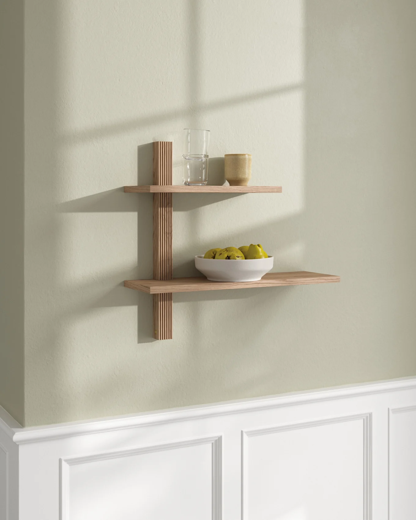 Zwei helle Holz-Schwebebretter an einer hellgrünen Wand. Oberes Brett mit Glas und Tasse; unteres Brett mit weißer Obstschale.