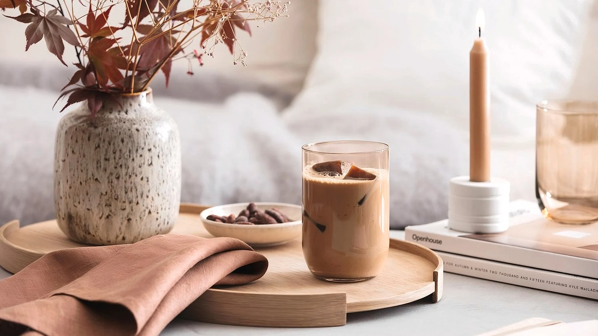 Lagom: Ein herbstlich gedeckter Tisch mit einer Vase und einer Kerze, im Fokus ist ein Like Longdrinkglas mit Eiskaffee von Villeroy & Boch.