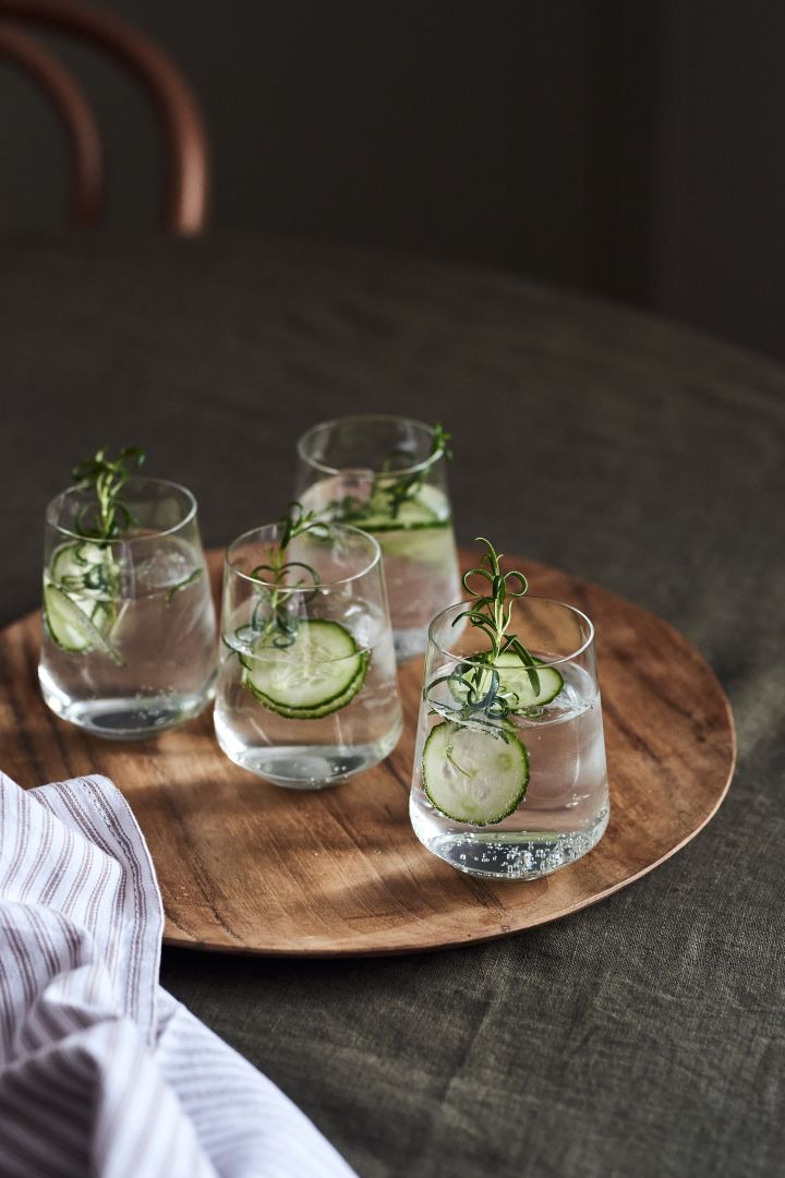 4 Cocktailrezepte für besondere Anlässe - Iittala Essence Glas auf dem Muubs Teak Teller.