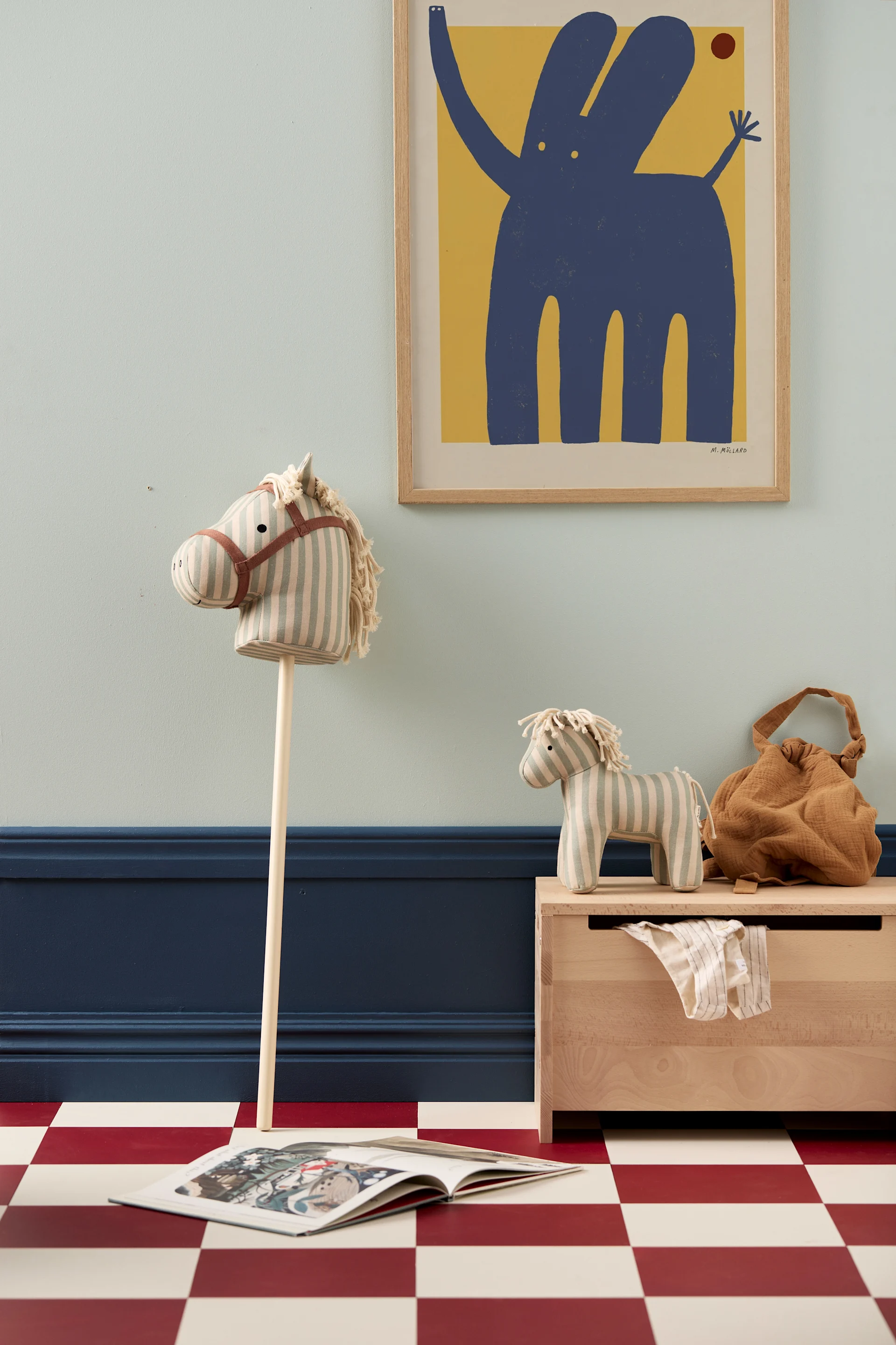 Holzmöbel sind eine tolle Idee für das Kinderzimmer, hier sehen Sie die Saga Holzaufbewahrungsbox von Kids Concept mit einem Steckenpferd aus Holz. 