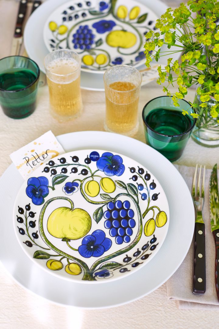 Decken Sie den Tisch für Mittsommer mit gemustertem und farbenfrohem Porzellan von Aravia, Grillbesteck von Gense und grünen Trinkgläsern von Iittala. 
