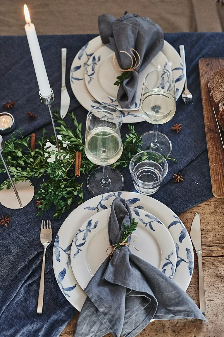 Romantisch gedeckter Weihnachtstisch mit blau-weißem Porzellan Havspil von Scandi Living und Fuga-Besteck von Gense. 