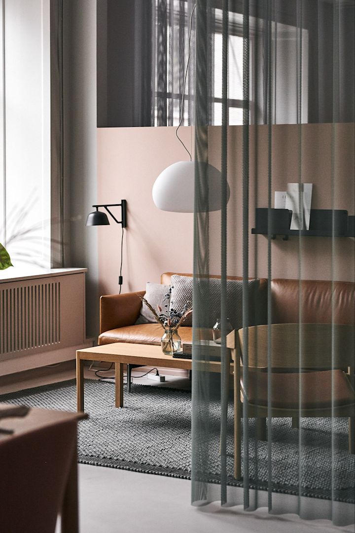 Das Wohnzimmer bei Muuto ist mit der Deckenleuchte Fluid und dem Ledersofa Outline eingerichtet. 