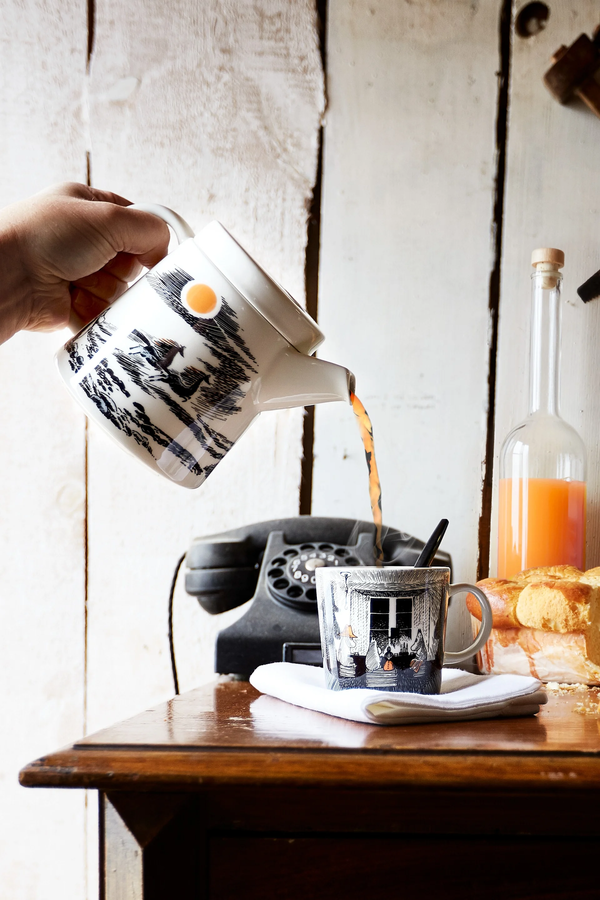 Die Treue zum Ursprung: Jemand gießt Tee aus der Mumin-Kanne in die dazugehörige Mumin-Tasse.