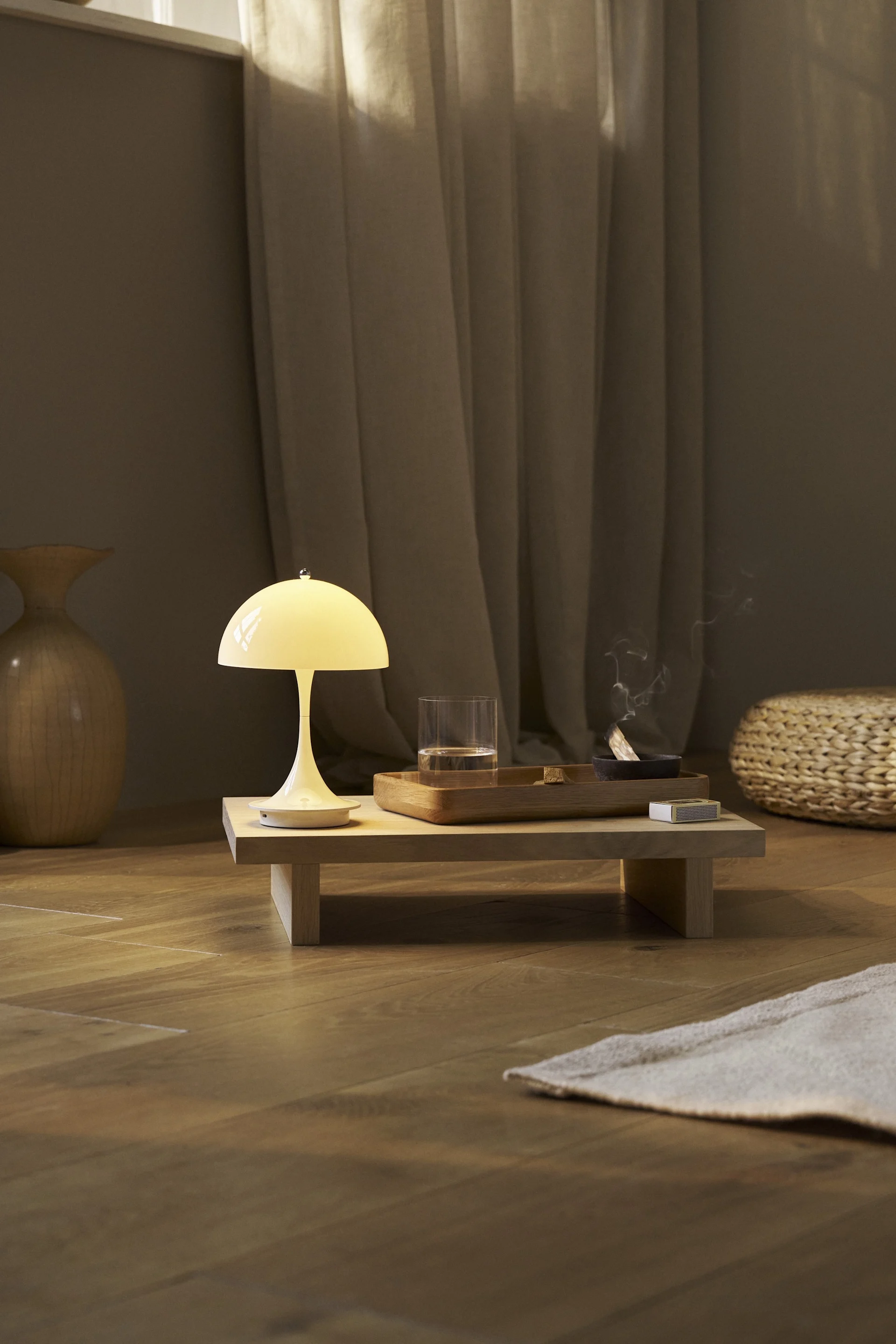 Die weiße Panthella Tischleuchte von Louis Poulsen steht in einem Raum, der im Japandi-Stil eingerichtet ist.