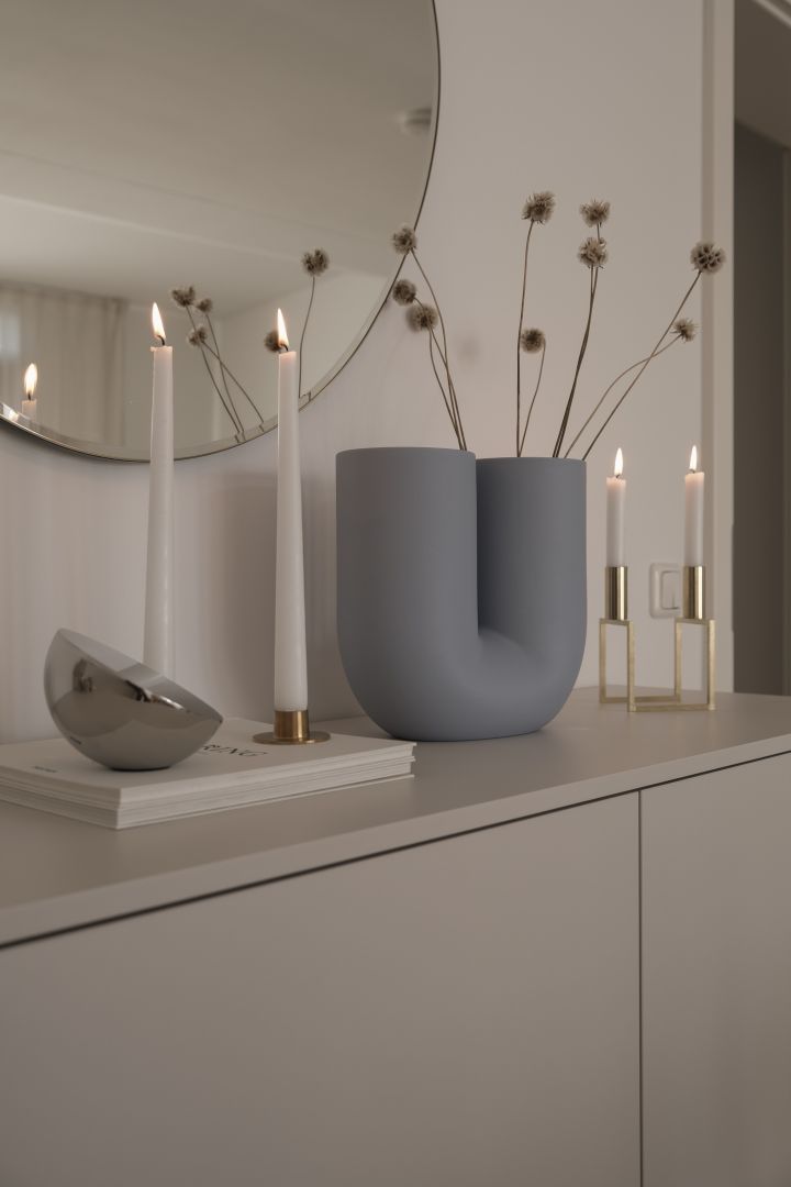 Kreieren Sie ein gemütliches Hygge-Wohnzimmer mit leuchtenden Kerzen wie diesen von Ester & Erik und der Kink Vase von Muuto.
