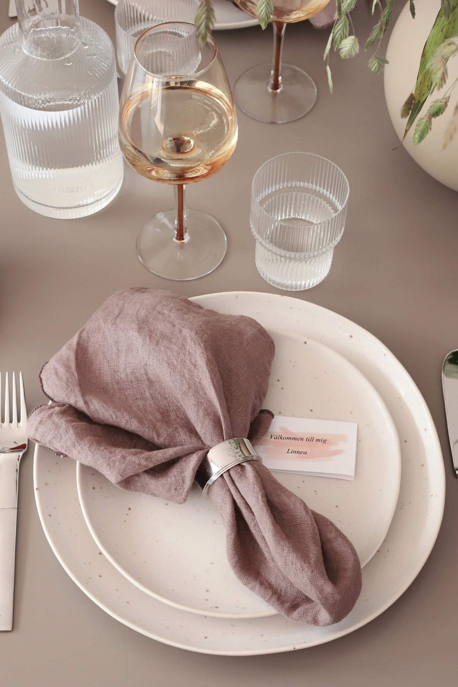 Ein Tipp für das Falten von Servietten mit einem Serviettenring ist die Kombination einer rosafarbenen Serviette mit einem Pyramiden-Serviettenring von Georg Jensen für einen stilvollen Look.