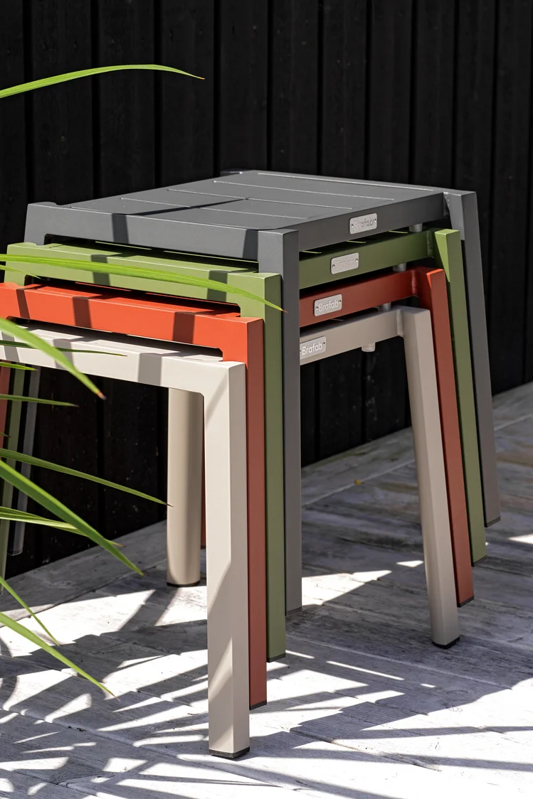 Zu den Gartenmöbel-Trends 2025 gehören auch multifunktionale Möbel. Die Hocker aus der Delia-Kollektion von Brafab, hier in vier verschiedenen Farben übereinander gestapelt, sind platzsparend und vielfältig verwendbar.