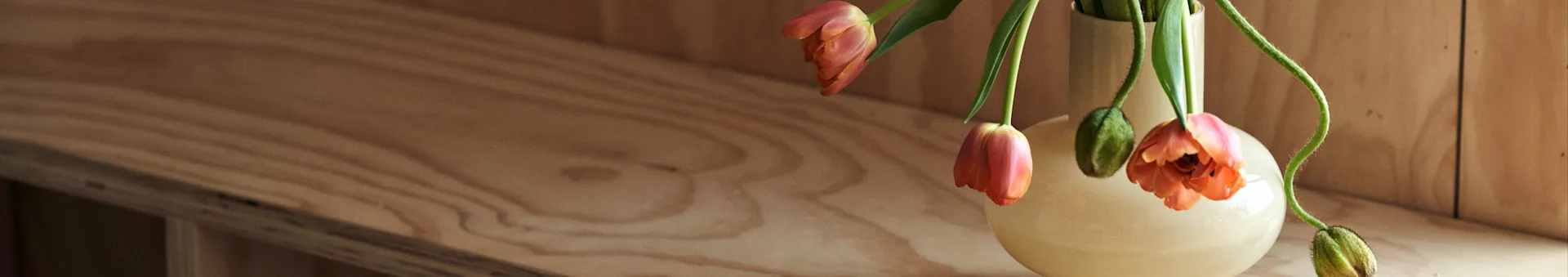 Lesen Sie auf Nordic Nest Tipps für die Inneneinrichtung und die neuesten Einrichtungstrends. Hier sehen Sie eine gelbe Vase von Marimekko mit orangefarbenen Tulpen darin. 