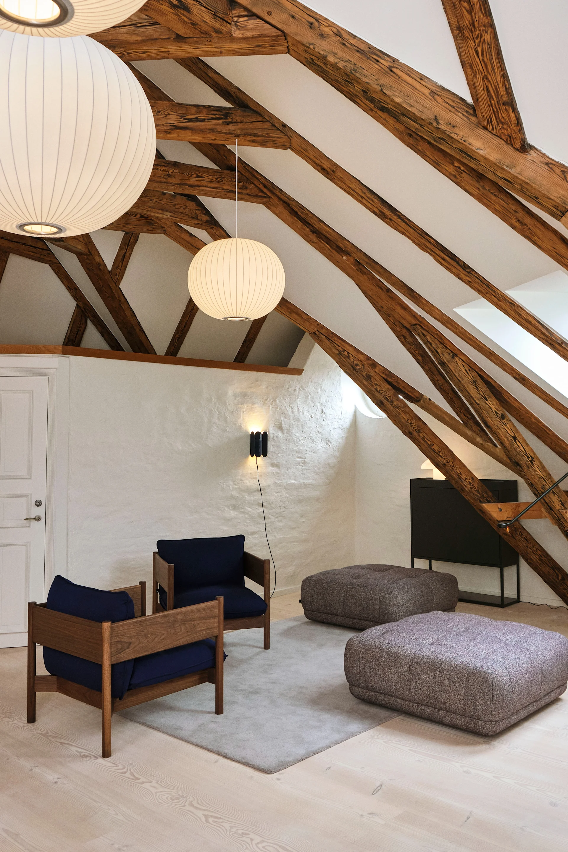 Deckenleuchten fürs Wohnzimmer: In einem Wohnzimmer mit hoher Decke mit Holzbalken hängen mehrere Nelson Bubble Ball Pendelleuchten von Hay.