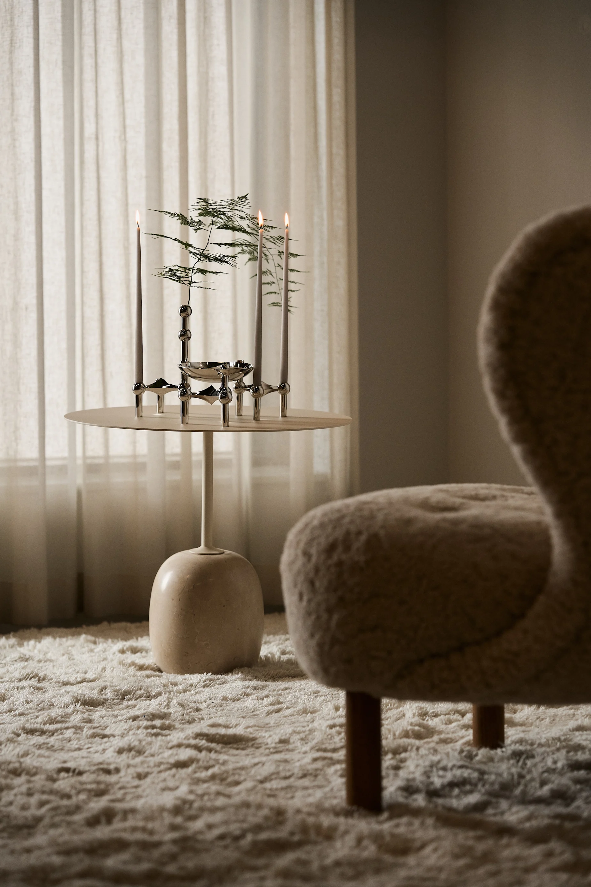 Ein beigefarbenes Wohnzimmer mit einem dekorierten Couchtisch mit Stoff Nagel Kerzenhaltern.