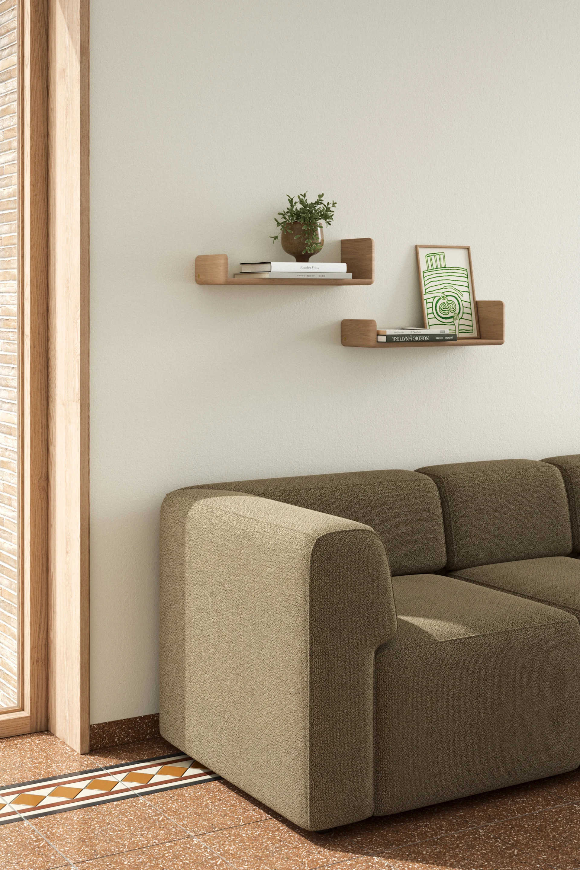 Ein gemütliches Wohnzimmer mit einem beigen Sektionssofa, Wandregalen aus Holz mit Büchern und einer Pflanze sowie einem gemusterten Fliesenboden.