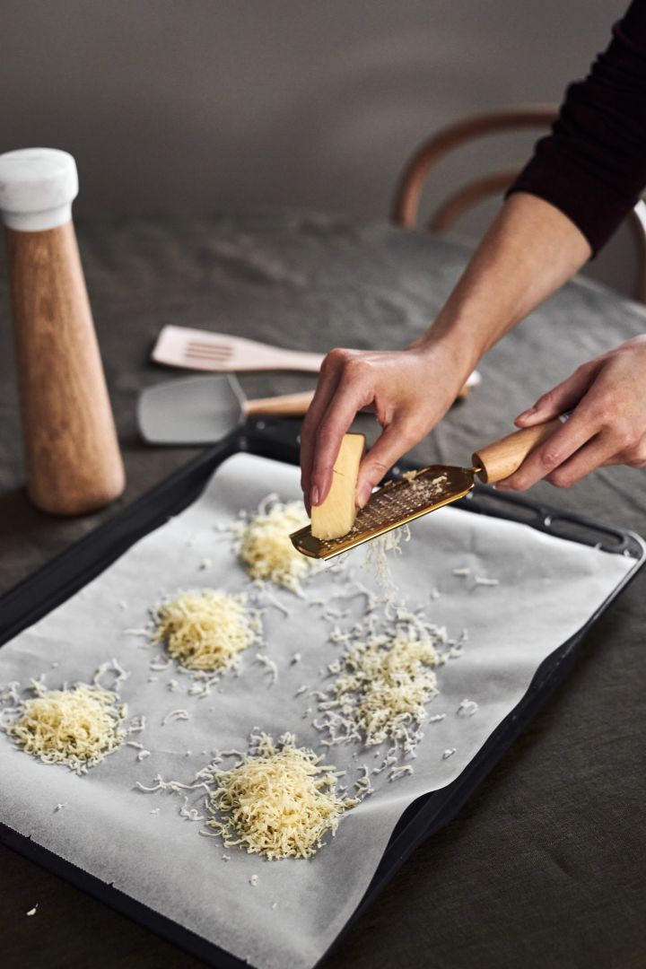 Leckere Cheddar-Körbchen sind eines der einfachen Vorspeisenrezepte, welche Sie Ihren Gästen dieses Silvester servieren können. Bereiten Sie die Körbe vor, indem Sie Käse mit der Handreibe von Bloomingville in kleine Häufchen reiben.