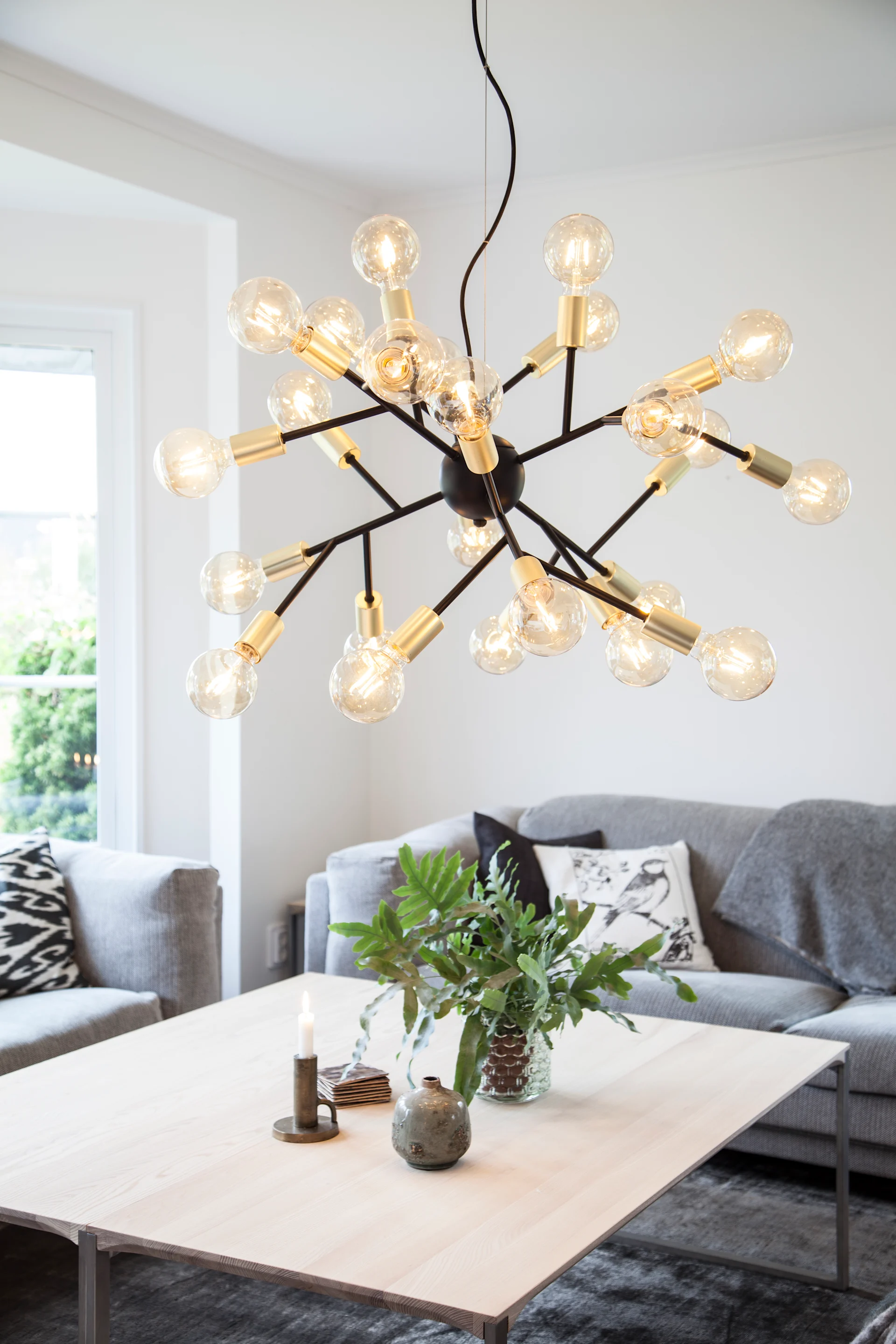 Über einem Couchtisch hängt die außergewöhnliche Heroes-Deckenleuchte von By Rdens.