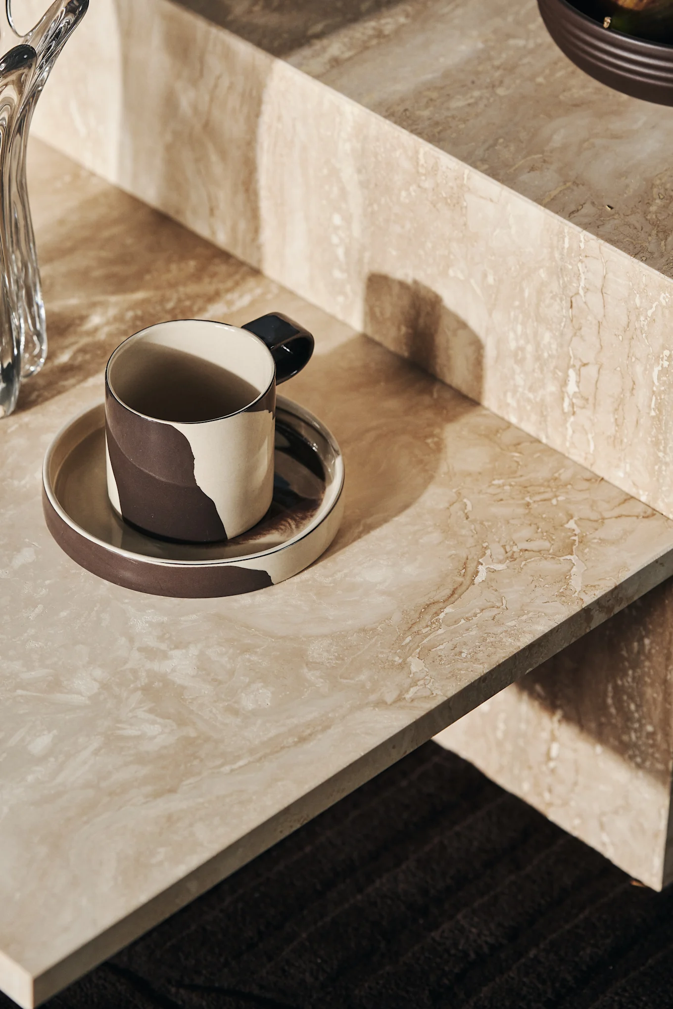Die Inlay Tasse mit Untersetzer auf dem Distinct Couchtisch, beides von ferm LIVING.