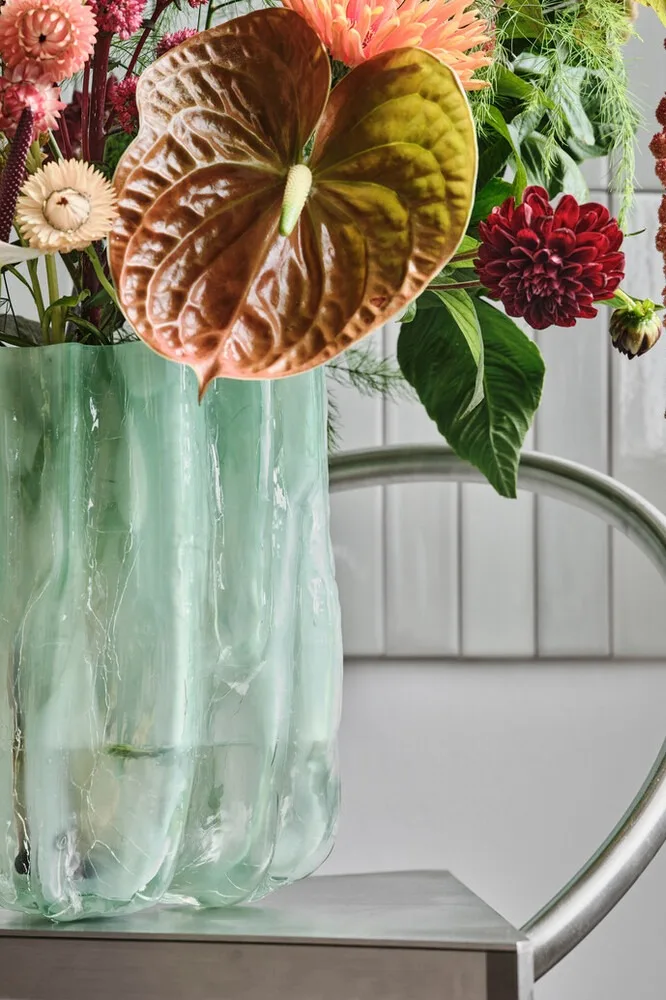 Blaue Crackle Vase von Kosta Boda mit einem Blumenstrauß. 