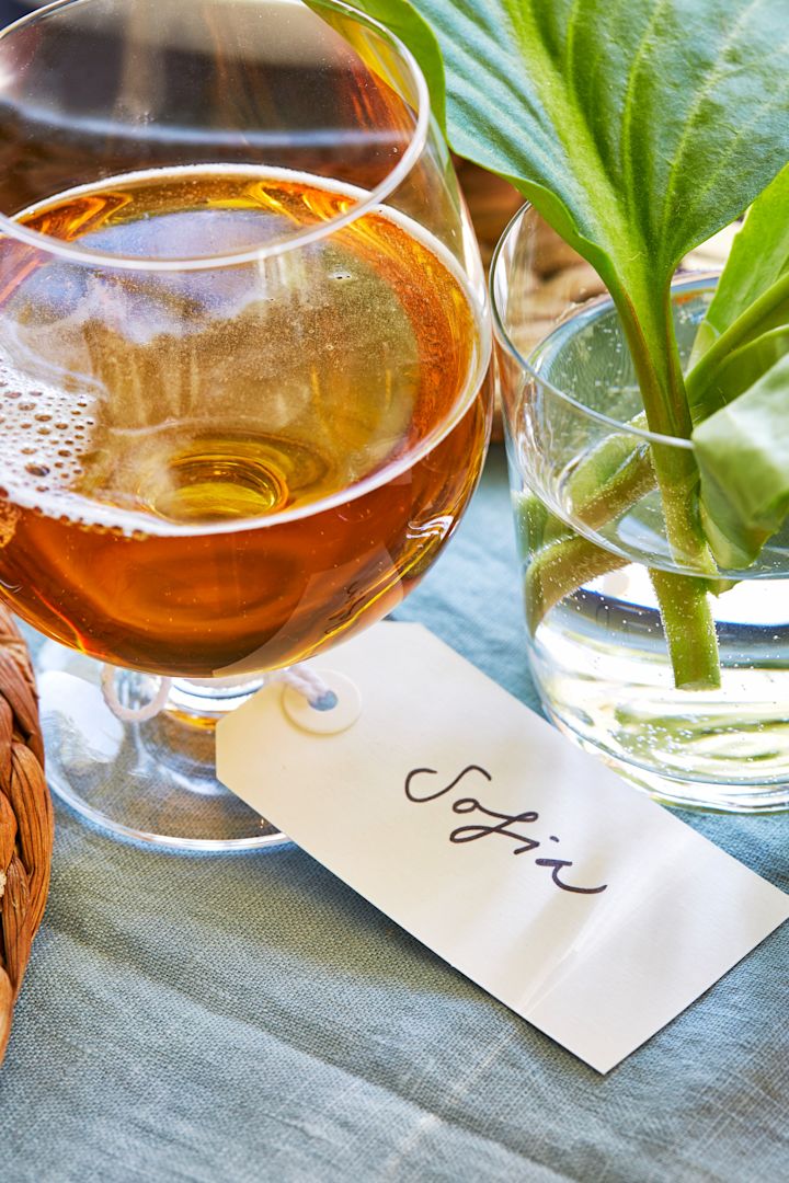 Mit handgeschriebenen Namensschildern an jedem Glas schaffen Sie etwas Besonderes für jeden Gast, wenn Sie den Tisch für Mittsommer decken. 