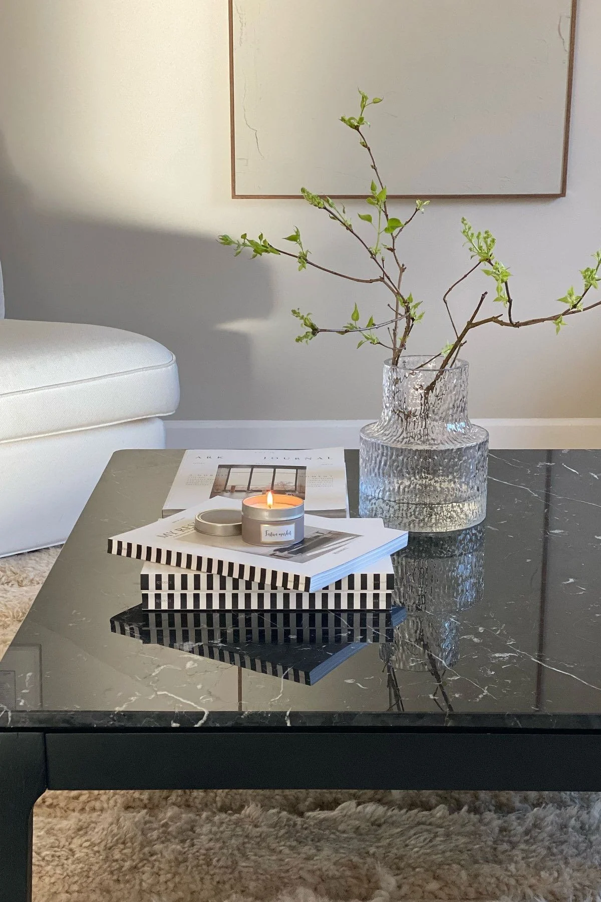 Ein schwarzer Couchtisch, dekoriert mit Büchern und der Skrufs Kolonn Vase.