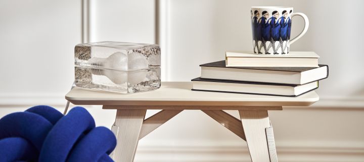 Ein kleiner weißer Holztisch von Design House Stockholm, auf dem die Block Leuchte und die Farbror Blå Tasse zu sehen sind.
