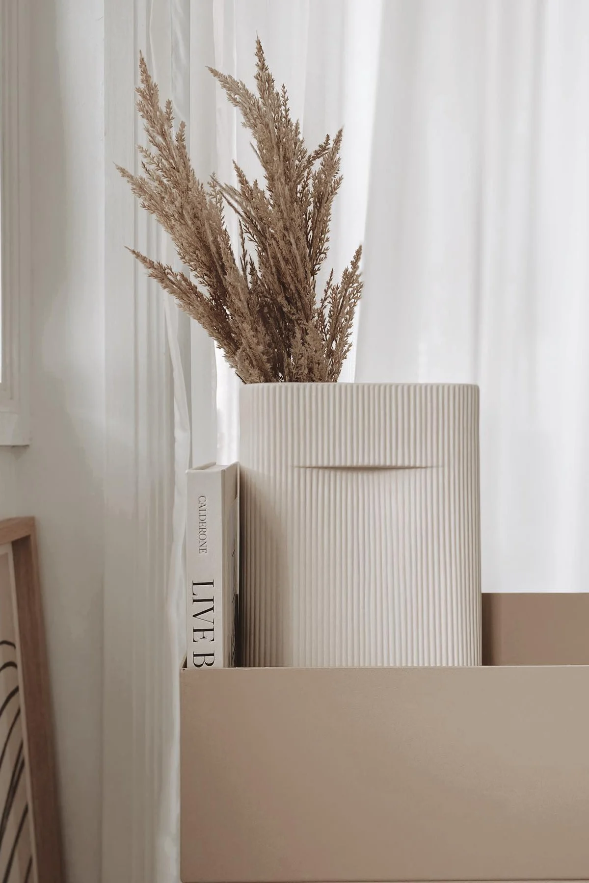 DEr Lagom-Wohnstil bedeutet auch zurückhaltende Farben. In einer beigefarbenen Plant box von Ferm Living steht die Ridge Vase von Muuto mit Trockenblumen darin im Zuhause von @beige_and_co.