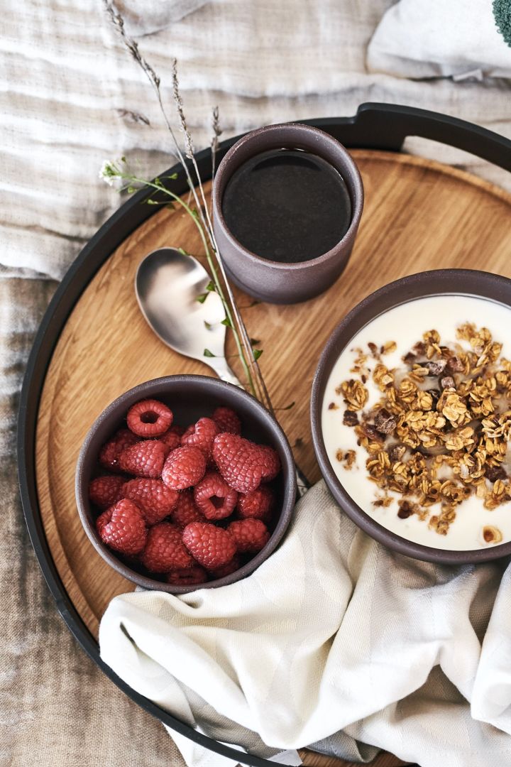 Servieren Sie ein luxuriöses Frühstück auf einem wunderschönen Tablett von Eva Solo und genießen Sie Leckereien wie Früchte und Müsli aus Schalen von Ferm Living