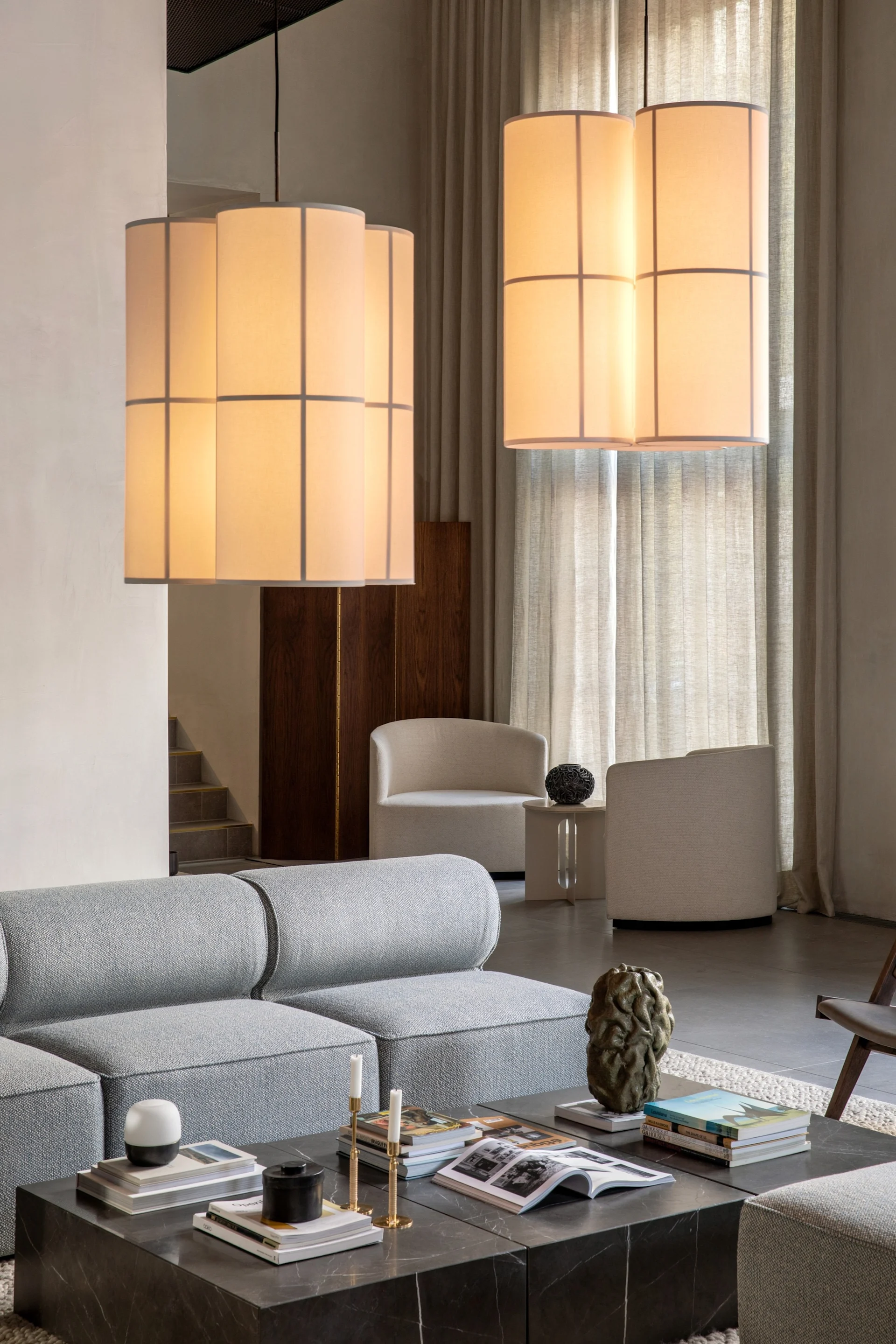 Die Hashira Cluster Pendelleuchte von Audo Copenhagen hängt in einem Wohnzimmer über dem Couchtisch.