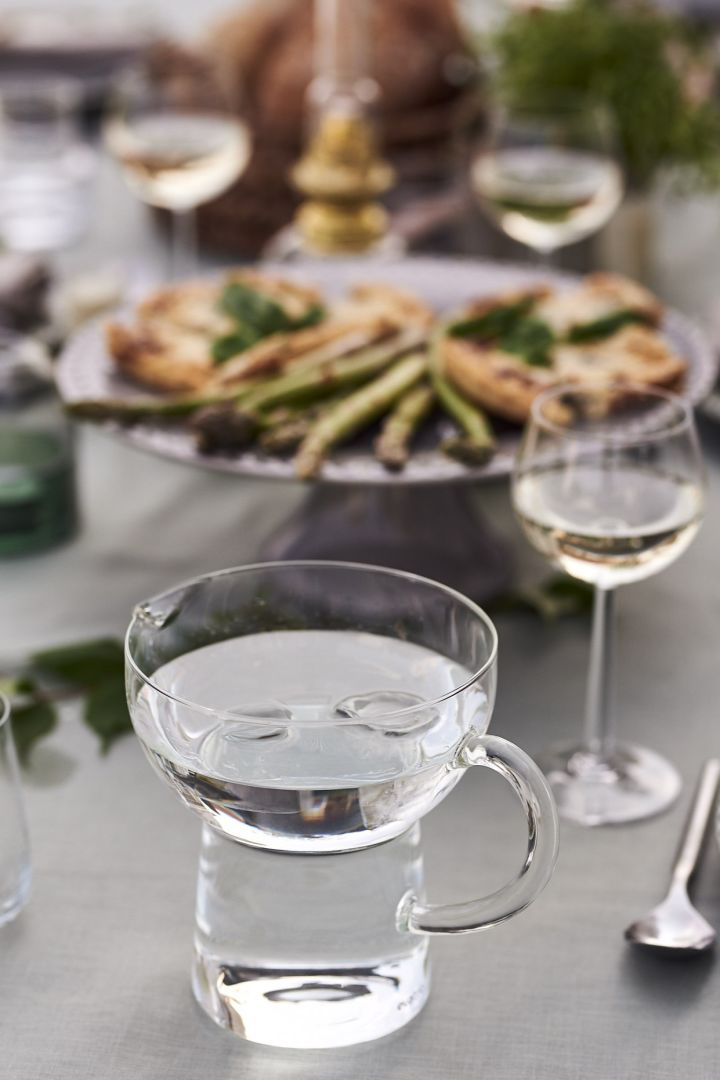 Der Glaskrug Eva trio von Eva Solo steht auf dem Tisch, damit die Gäste bei einer Gartenparty ihren Durst löschen können.