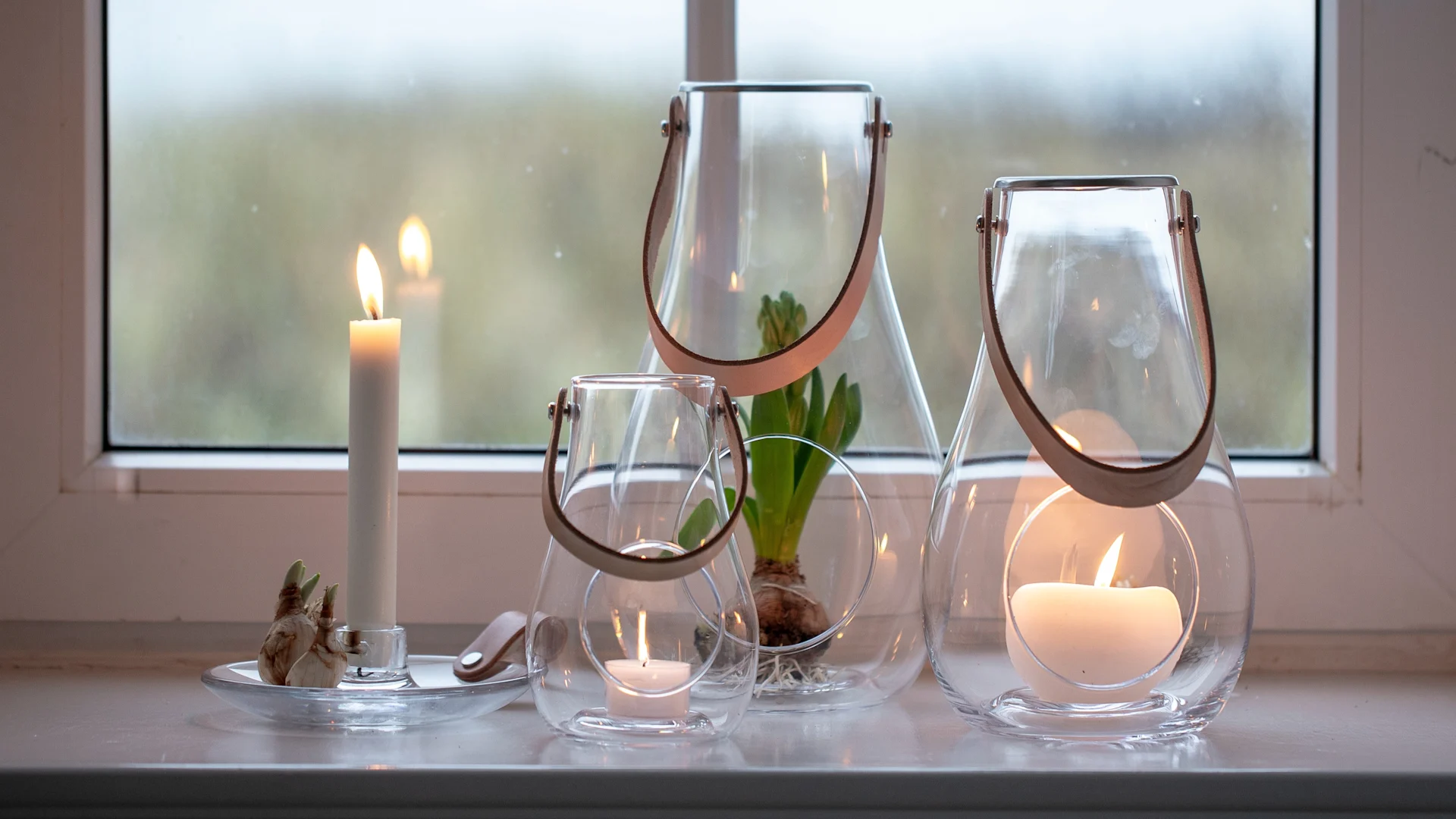 Fensterbank dekorieren: Die Design with Light Laternen von Holmegaard in verschiedenen Größen stehen auf einer Fensterbank.