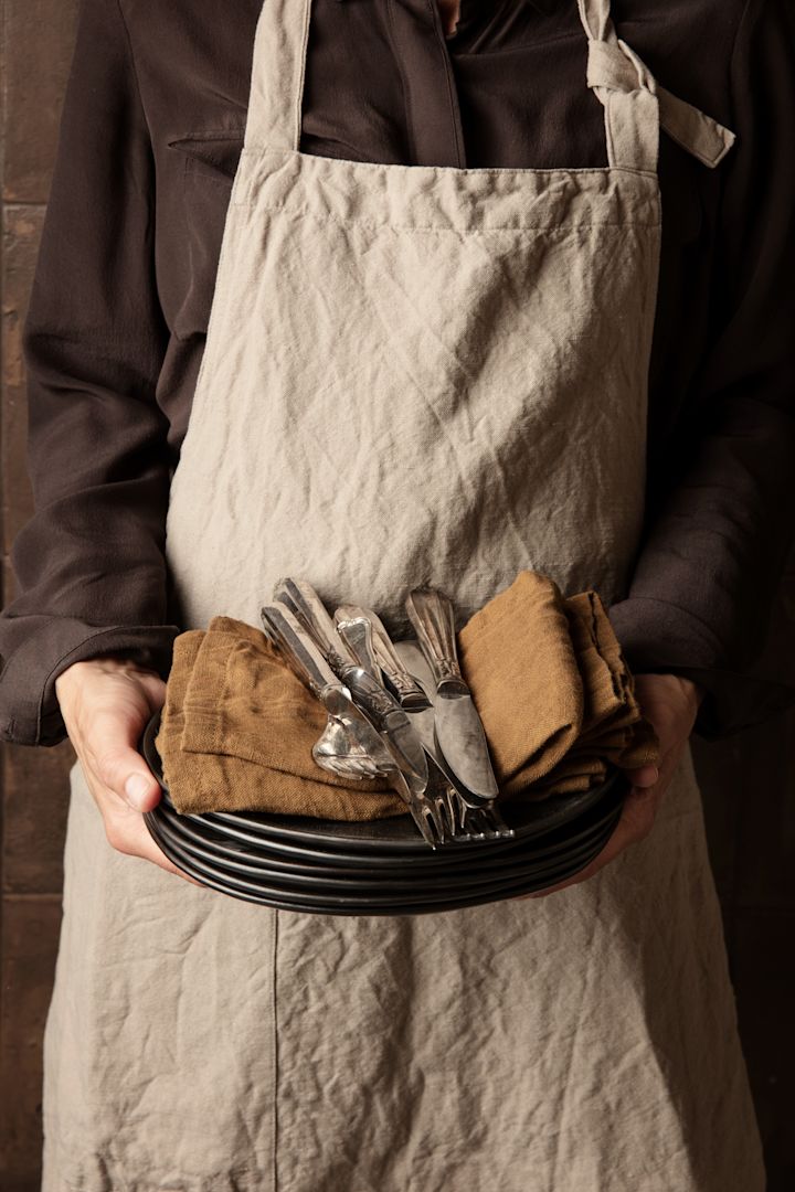 Mehr Freude am Kochen –  hier sehen Sie die stilvolle Schürze Hale in der Farbe Sand von Ferm Living.