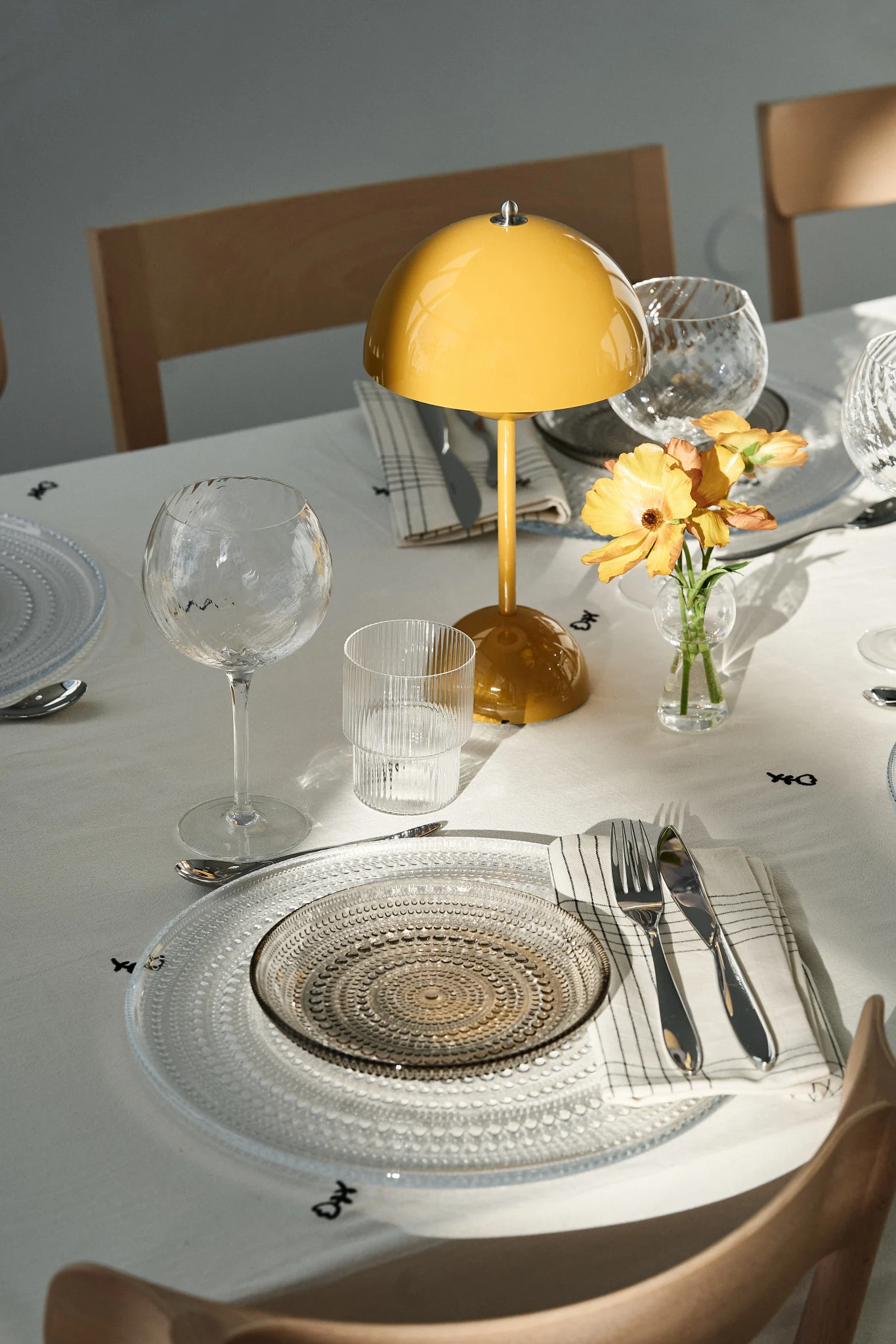 Der gedeckte Tisch ist ein wichtiger Bestandteil jeder Party. Hier sehen Sie eine Partydekoration mit einer tragbaren Flowerpot-Lampe und festlichen Glastellern.