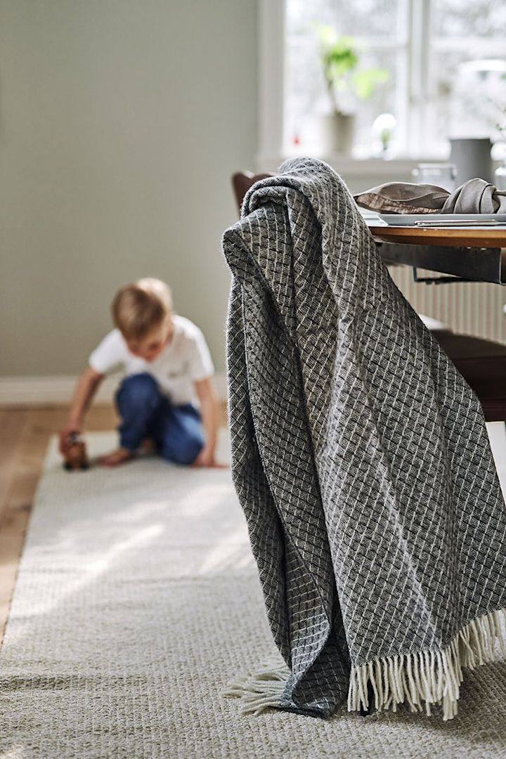 Die graue Wicker Wolldecke von Scandi Living hängt im Essbereich.