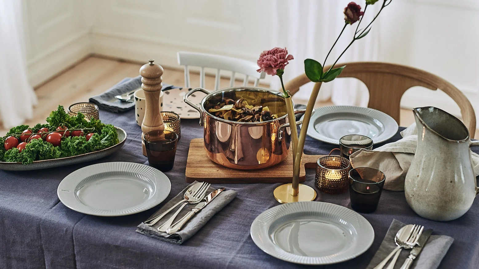 Eine alltägliche Tischdekoration, bei der das Schneidebrett von House Doctor als Untersetzer für den Topf von Eva Solo verwendet wird.