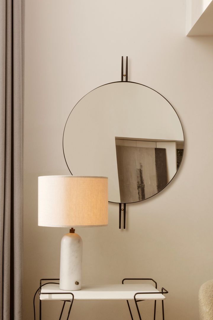 Entdecken Sie die besten Tipps von GUBI für die Platzierung von Beleuchtung in Ihrem Zuhause. Hier sehen Sie die GUBI Gravity Tischleuchte aus weißem Marmor auf einem Beistelltisch vor einem Spiegel.