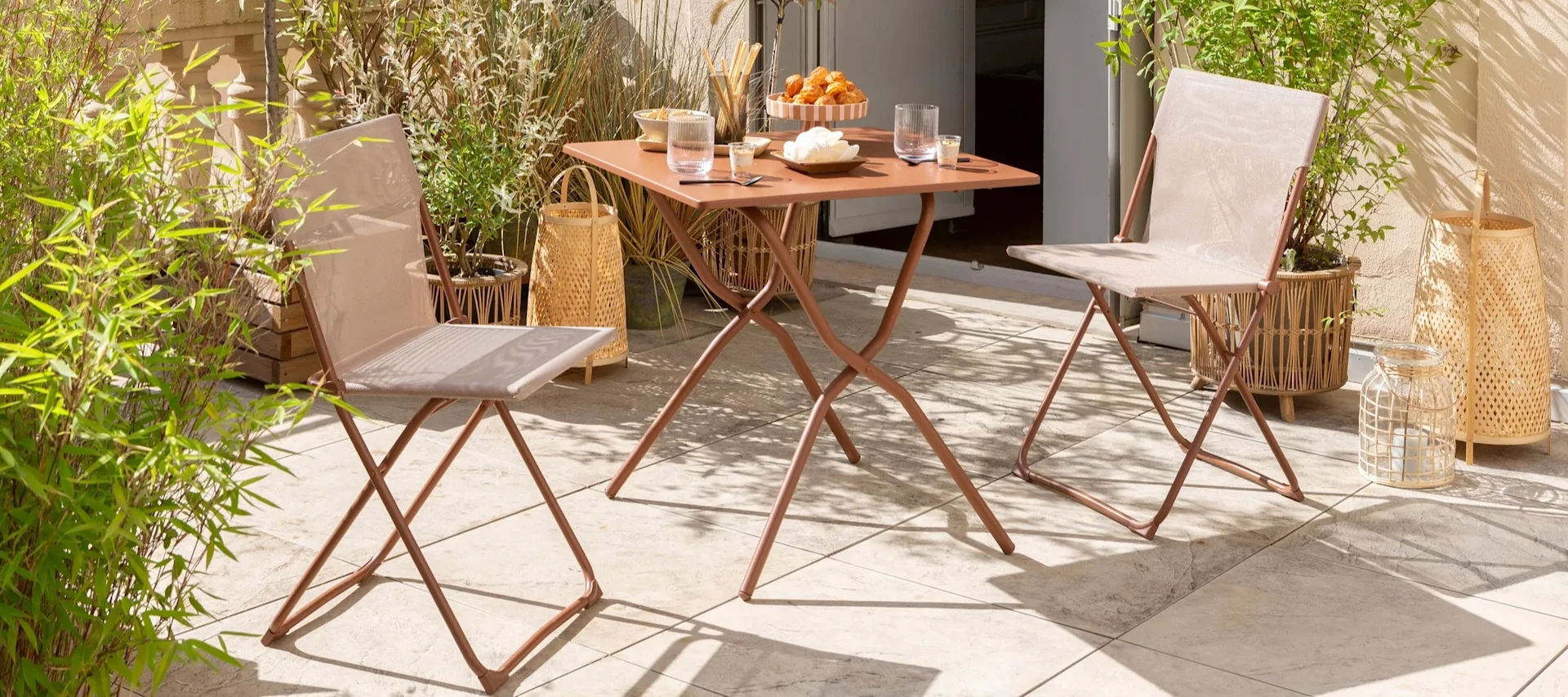 Balkon Ideen: Diese Outdoor-Möbel, hier sehen Sie einen kleinen Tisch und Klappstühle von Lufuma in der Farbe Terrakotta, sind perfekt für einen kleinen Balkon, funktionieren aber auch auf einer Terrasse oder auf der Veranda.