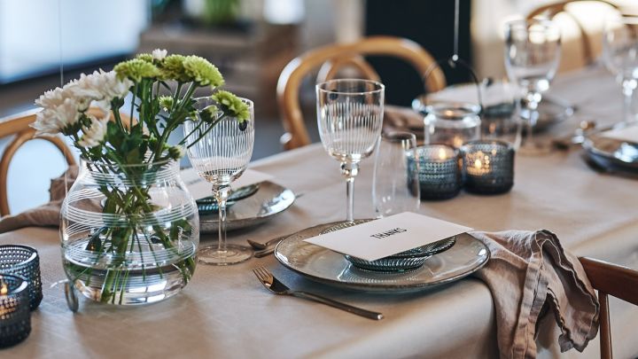 Tischgedeck mit rustikalem Nordic Sand Teller und Weinglas von House Doctor. Auf dem Tisch steht auch die Glasvase Omaggio von Kähler.