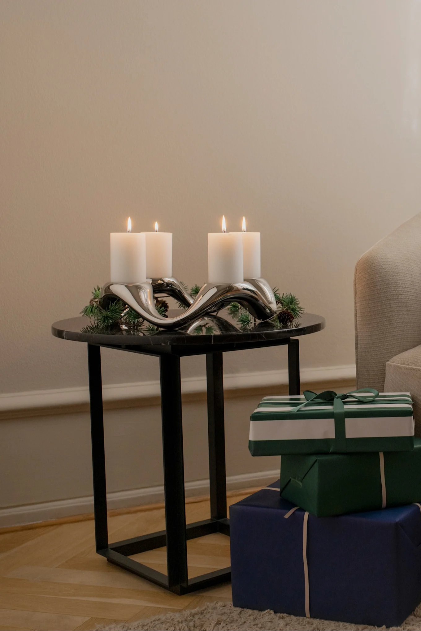 Auf einem Beistelltisch steht der mit Tannengrün dekorierte Cobra Kerzenhalter von Georg Jensen.