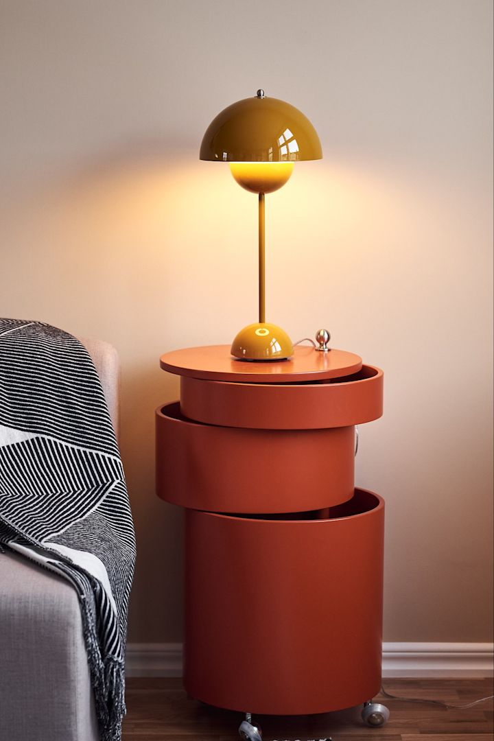 Die gelbe Flowerpot Tischleuchte und der orangefarbene Beistelltisch von Verpan sorgen für aufregende Kontraste im neutral gestalteten Wohnzimmer.