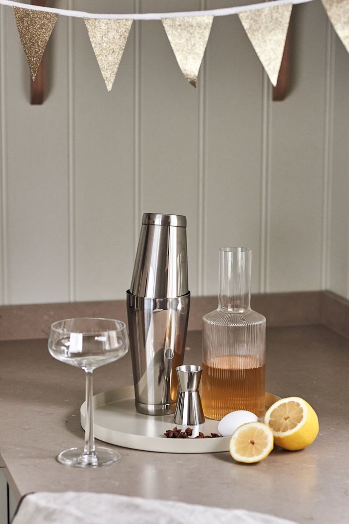 4 Cocktailrezepte für besondere Anlässe – ein gelungenes Fest. Hier der Dorre Cocktailshaker, der Rosendahl Messbecher und die Ripple Karaffe von Ferm Living auf einem Tablett von Cooee Design.