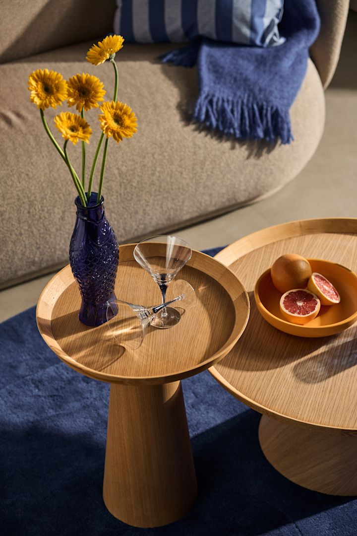 Die Wohntrends für den Herbst 2023 sind bunt und gewagt, wie hier mit blauen Akzenten in einem verspielten Dekor mit einer Vase in Form eines Fisches und Sonnenblumen darin.